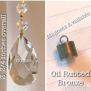 May include: A crystal teardrop pendant with a gold-tone cap and a 50mm measurement. The pendant is 3 3/4 inches long overall. The image also shows a close-up of an oil-rubbed bronze magnetic cap. Magnets are available.