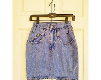 May include: A light blue denim skirt with a high waist and a button closure. The skirt has two front pockets and two back pockets.