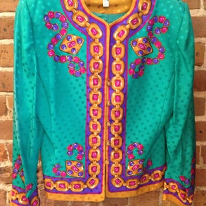 May include: A teal green blazer with a polka dot pattern and a gold, purple, and pink chain design. The blazer has a button closure and long sleeves. The label reads "Adrienne Vittadini PAPELL".