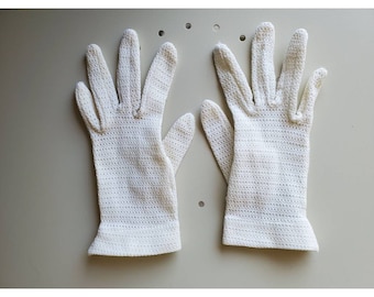 May include: A pair of white crocheted gloves. The gloves are made of a delicate, open-weave fabric.