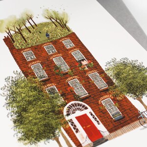 May include: A red brick building with a green roof and a red door. The building has many windows and is surrounded by trees.