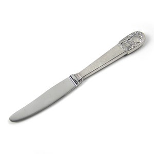 May include: A silver butter knife with a detailed floral design on the handle.
