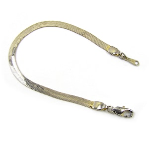 May include: A gold-toned snake chain bracelet with a lobster clasp.