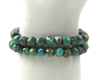 May include: A double-strand bracelet made of turquoise-colored beads. The beads are faceted and have a slightly irregular shape.