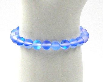 May include: A light blue beaded bracelet with iridescent shimmer. The bracelet is made of round, smooth beads and is approximately 7 inches in length.