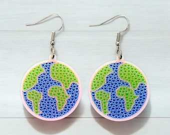 May include: A pair of dangle earrings featuring a round, blue and green globe design made of tiny hearts. The globe is surrounded by a white border.