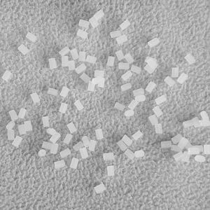 May include: A close-up image of a white, textured surface with a scattered arrangement of small, white, rectangular objects.