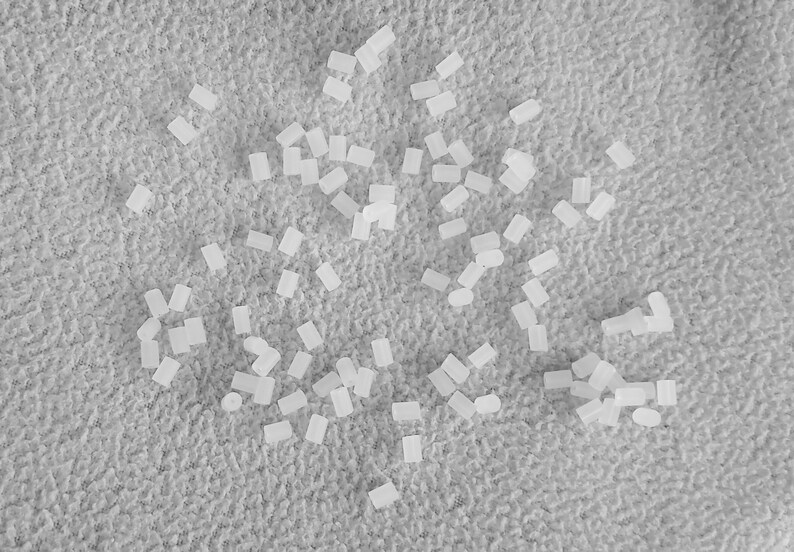 May include: A close-up image of a white, textured surface with a scattered arrangement of small, white, rectangular objects.
