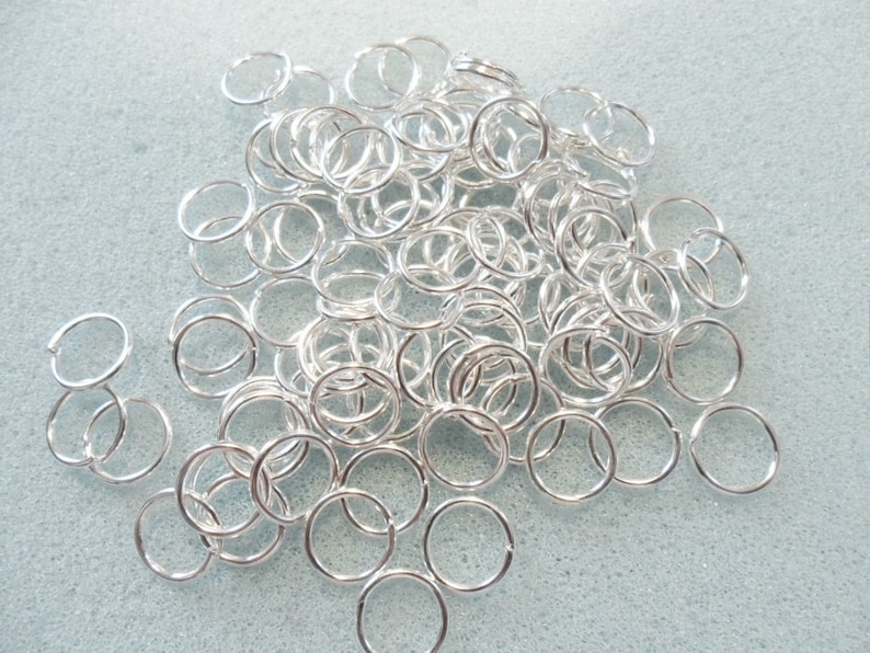 Puede incluir: Un mont&oacute;n grande de anillos de salto plateados. Los anillos son peque&ntilde;os y redondos, y todos son del mismo tama&ntilde;o.