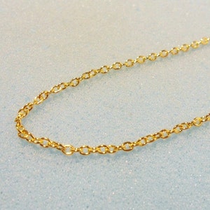 Peut inclure: Un collier en cha&icirc;ne dor&eacute;e avec un design d&eacute;licat et li&eacute;.