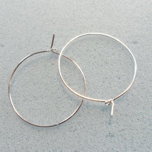 May include: A pair of silver hoop earrings. The earrings are simple and elegant, and they would be a great addition to any jewelry collection.