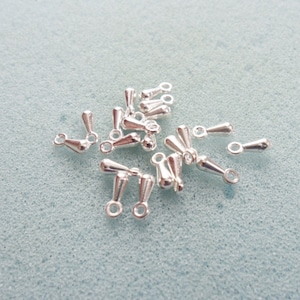 May include: A group of silver teardrop-shaped jewelry findings with a loop at the top. These findings are perfect for adding a touch of elegance to your jewelry designs.