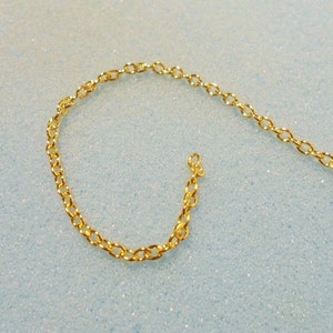 Peut inclure: Un collier en cha&icirc;ne dor&eacute;e avec un motif de maillons d&eacute;licats de forme ovale.