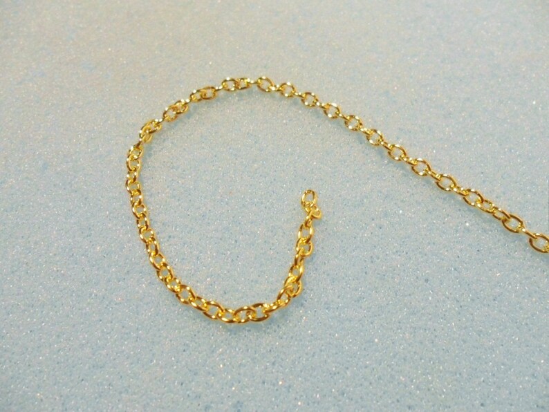Peut inclure: Un collier en cha&icirc;ne dor&eacute;e avec un motif de maillons d&eacute;licats de forme ovale.