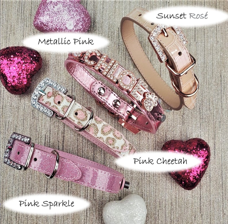 May include: Five different dog collars in pink and rose gold. The collars are decorated with rhinestones, glitter, and a cheetah print. The collars are labeled "Metallic Pink", "Pink Sparkle", "Pink Cheetah", "Sunset Ros&eacute;", and "Chole".