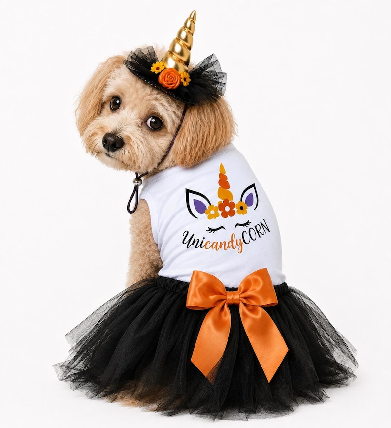 May include: A white pet tank top dress featuring a graphic of a unicorn face with orange flowers and the text Uni-candy-CORN, paired with a black tulle skirt, an orange satin bow, and a matching black tulle headband with a gold unicorn horn.