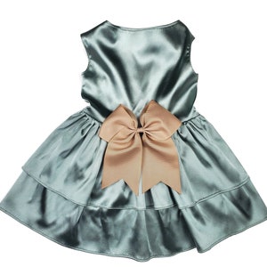 K&ouml;nnte beinhalten: Ein hellblaues Satin-Kleid mit einer gro&szlig;en braunen Schleife auf der R&uuml;ckseite.