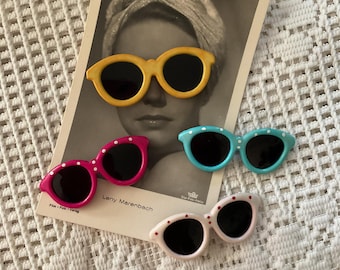 Juego de cuatro broches y alfileres vintage de los años 80. Gafas de sol de plástico. Originales, no reproducciones. Los cuatro se venden juntos. Sin marcar. Sin firmar.
