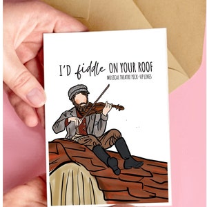 May include: A white card with a cartoon illustration of a man playing a fiddle on a rooftop. The text on the card reads "I'd fiddle on your roof" and "Musical Theatre Pick-Up Lines".