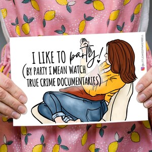 May include: A white card with a cartoon illustration of a person watching television. The text on the card reads "I like to party! (By party I mean watch true crime documentaries)"