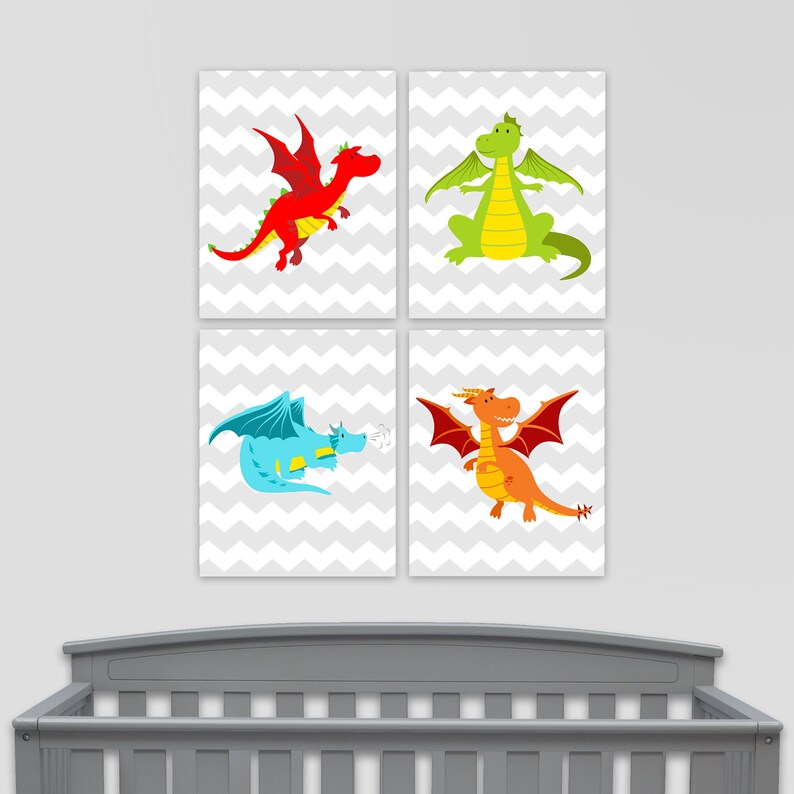 May include: Four framed art prints featuring colorful cartoon dragons. Each dragon is a different color: red, green, blue, and orange. The background is a gray and white chevron pattern. The prints are displayed above a gray crib.