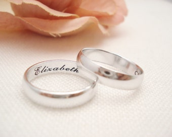 May include: Two silver wedding bands, one with the name "Elizabeth" engraved on the inside.