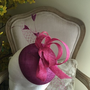 Gorgeous magenta round fascinator with magenta loops, feathers and netting. Stunning!
