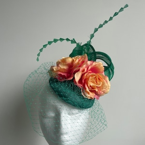 Green fascinator with silk abaca loops, feathers, netting and orange flowers. Made to order!