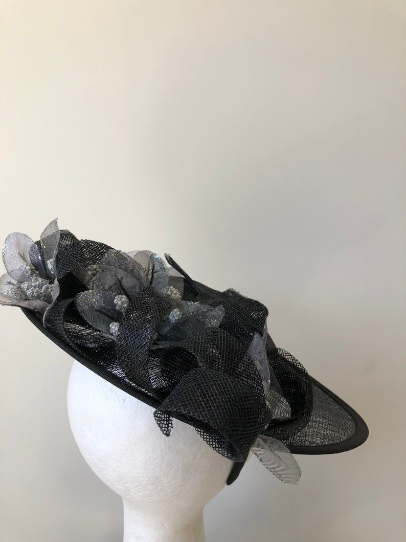 New black saucer fascinator with silver flowers and black loops on a headband!