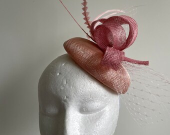 Pink fascinator with round base and pink loops, netting and feathers. Made to order!