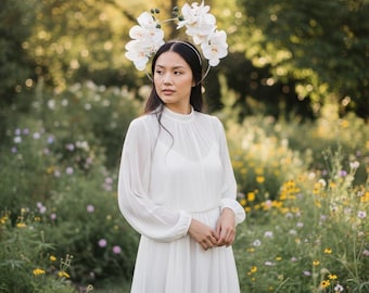 Tocado con halo de orquídeas blancas y cinta plateada.