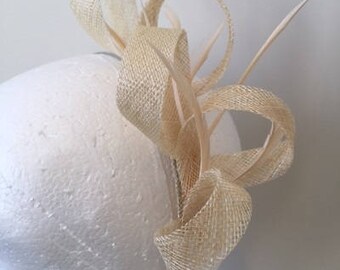 Cream loop sinamay fascinator with biot feathers on a metal headband!