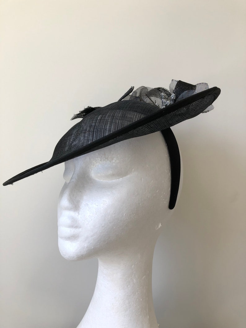 New black saucer fascinator with silver flowers and black loops on a headband!