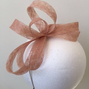 Pretty pink sinamay loop fascinator on a metal headband. Gorgeous on!