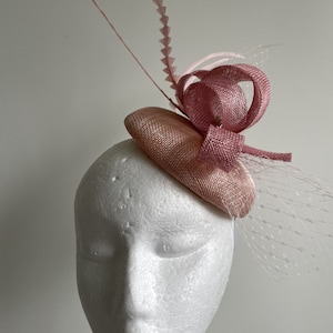 New pink coloured fascinator with sinamay loops, feathers and netting. Made to order!