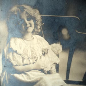 Antieke poppenkaart - klein meisje, edwardiaanse kanten jurk, bankstoel speelgoedpop, frans sepia 1900