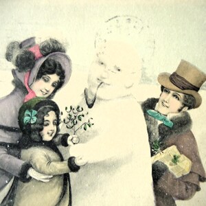 Carte postale ancienne de style Vienne - Couple victorien, chapeau haut de forme, bonhomme de neige pour petite fille, gui de Noël, neige teintée 1900