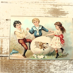 Tarjeta coleccionable antigua de Pascua: dibujo de un niño y una niña bailando alrededor de un gran huevo de Pascua, conejito y liebre, dorso en blanco, francés, 1900