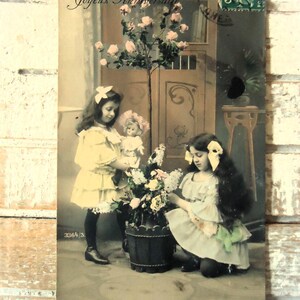 Carte postale ancienne pour enfant - Jouet de poupée, deux filles, rubans de robe en dentelle édouardienne, roses végétales, amies soeurs, française teintée 1900