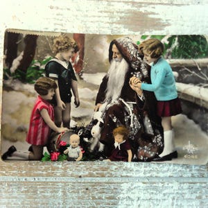 Antieke kerstkaart - lichte vouw - kerstman sneeuw, kinderen meisjes, cadeaus poppen speelgoed, frans getint 1900