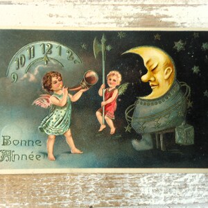 Cartão postal antigo de ano novo em relevo - Desenho em relevo, rosto de lua crescente, estrelas, anjos, música, alabarda, meio-dia, colorido, 1900