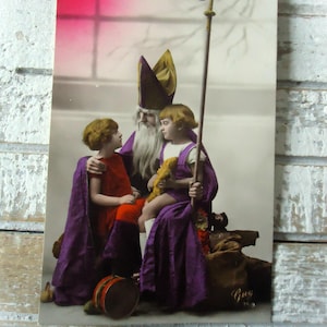 Antieke kerstkaart - Sinterklaas, tas met kerstcadeaus, twee meisjes, staf speelgoed trommels, Frans getint 1900