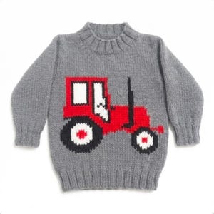 Puede incluir: Un suéter de punto gris con un diseño de tractor rojo. El tractor tiene ruedas negras y blancas y un tubo de escape negro. El suéter tiene cuello y puños de canalé y está hecho de un material suave y cálido.