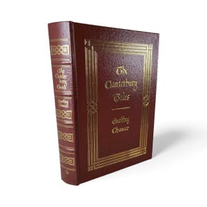 May include: A hardcover book titled "The Canterbury Tales" by Geoffrey Chaucer. The book has a burgundy cover with gold lettering and decorative gold accents. The spine also features gold lettering.