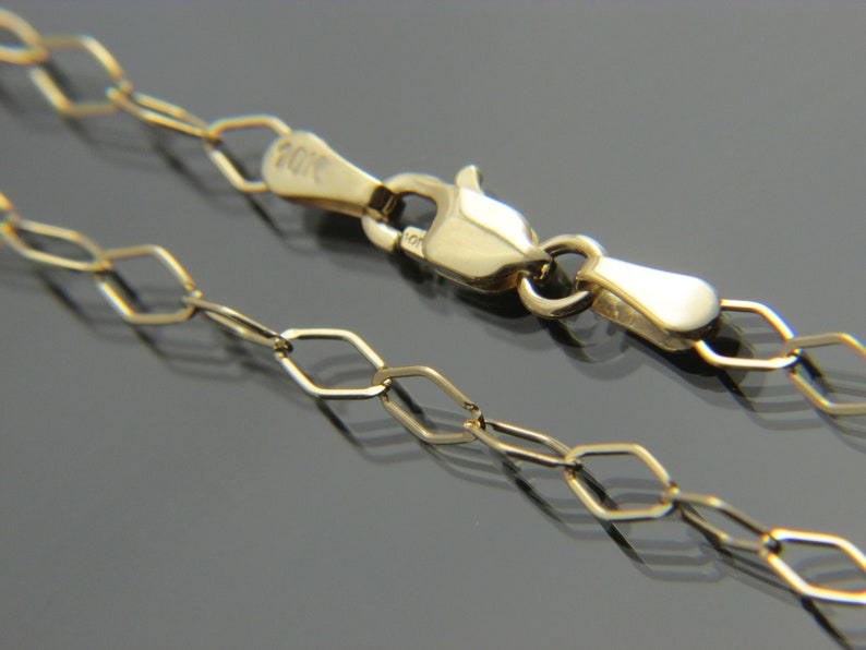 Puede incluir: Un collar de cadena de oro con cierre de mosquet&oacute;n. La cadena est&aacute; hecha de peque&ntilde;os eslabones ovalados planos.