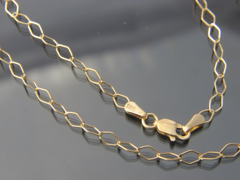 Puede incluir: Un collar de cadena de oro con cierre de langosta. La cadena est&aacute; hecha de peque&ntilde;os eslabones ovalados. El cierre est&aacute; marcado con "10K".