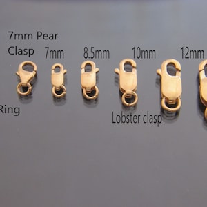 May include: A collection of gold-toned jewelry clasps arranged by size, including a 5mm ring clasp, a 7mm pear clasp, and lobster clasps labeled 7mm, 8.5mm, 10mm, 12mm, and 14mm. Each metal clasp features a spring-loaded mechanism and a small jump ring.