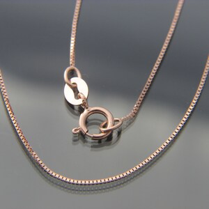 May include: A rose gold chain necklace with a lobster clasp closure.