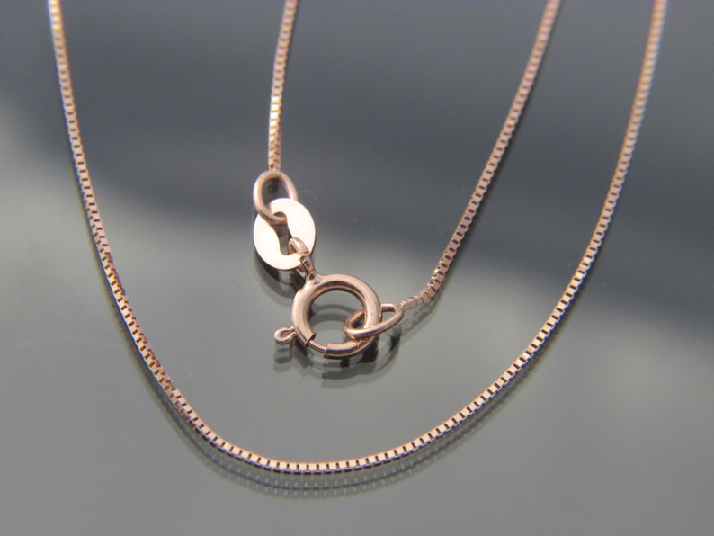 May include: A rose gold chain necklace with a lobster clasp closure.
