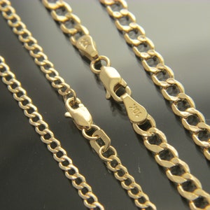 K&ouml;nnte beinhalten: Drei goldene Ketten in verschiedenen Breiten, alle im Curb-Link-Stil. Die Ketten liegen in einer Reihe, wobei die dickste Kette unten und die d&uuml;nnste Kette oben liegt. Die Ketten sind alle aus Gold und haben eine gl&auml;nzende Oberfl&auml;che.